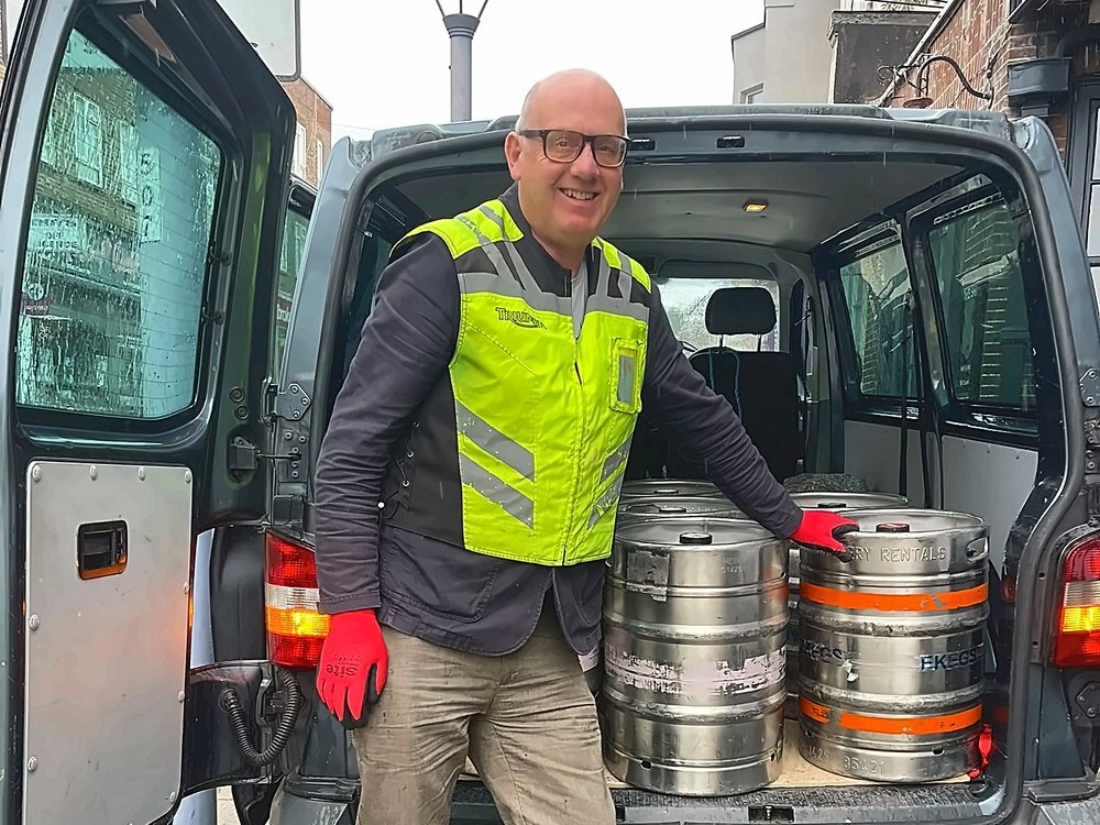 The Able Transport driver in a hi-vis vest beside the van loaded with beer kegs delivering to a pub